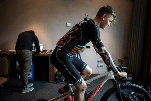 man with sensors attached riding stationary bike