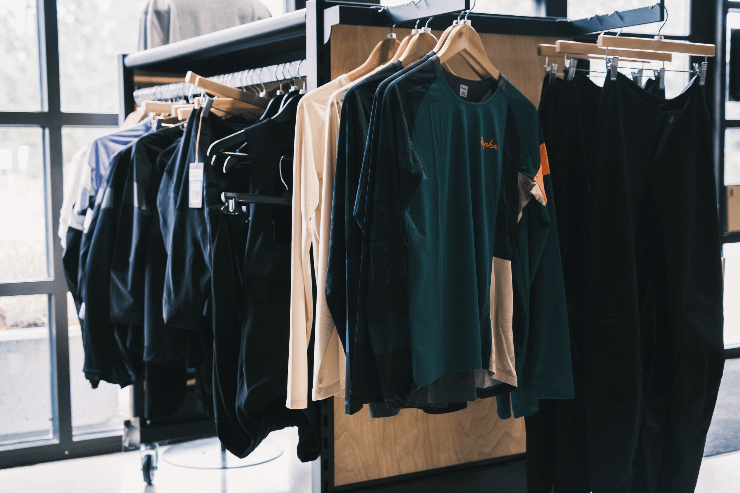 Assorted cycling clothes hanging on a rack in a show room 
