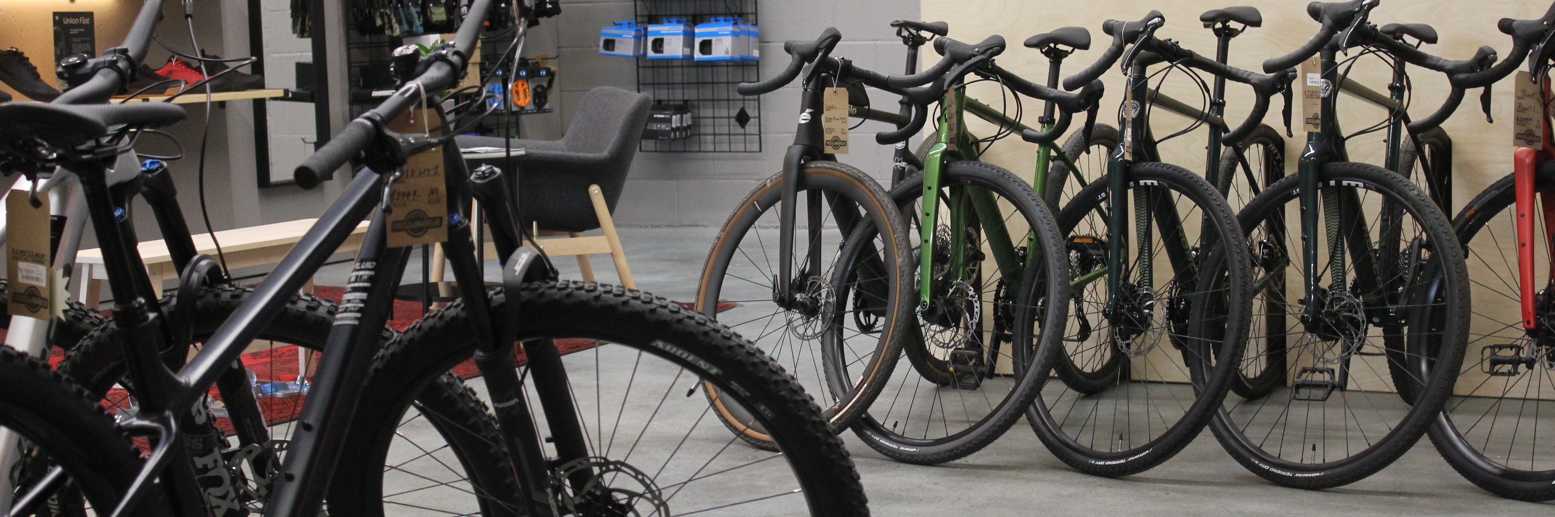 Full Cycle bicycle store with various bicycles on display, including a close-up of a black bicycle.