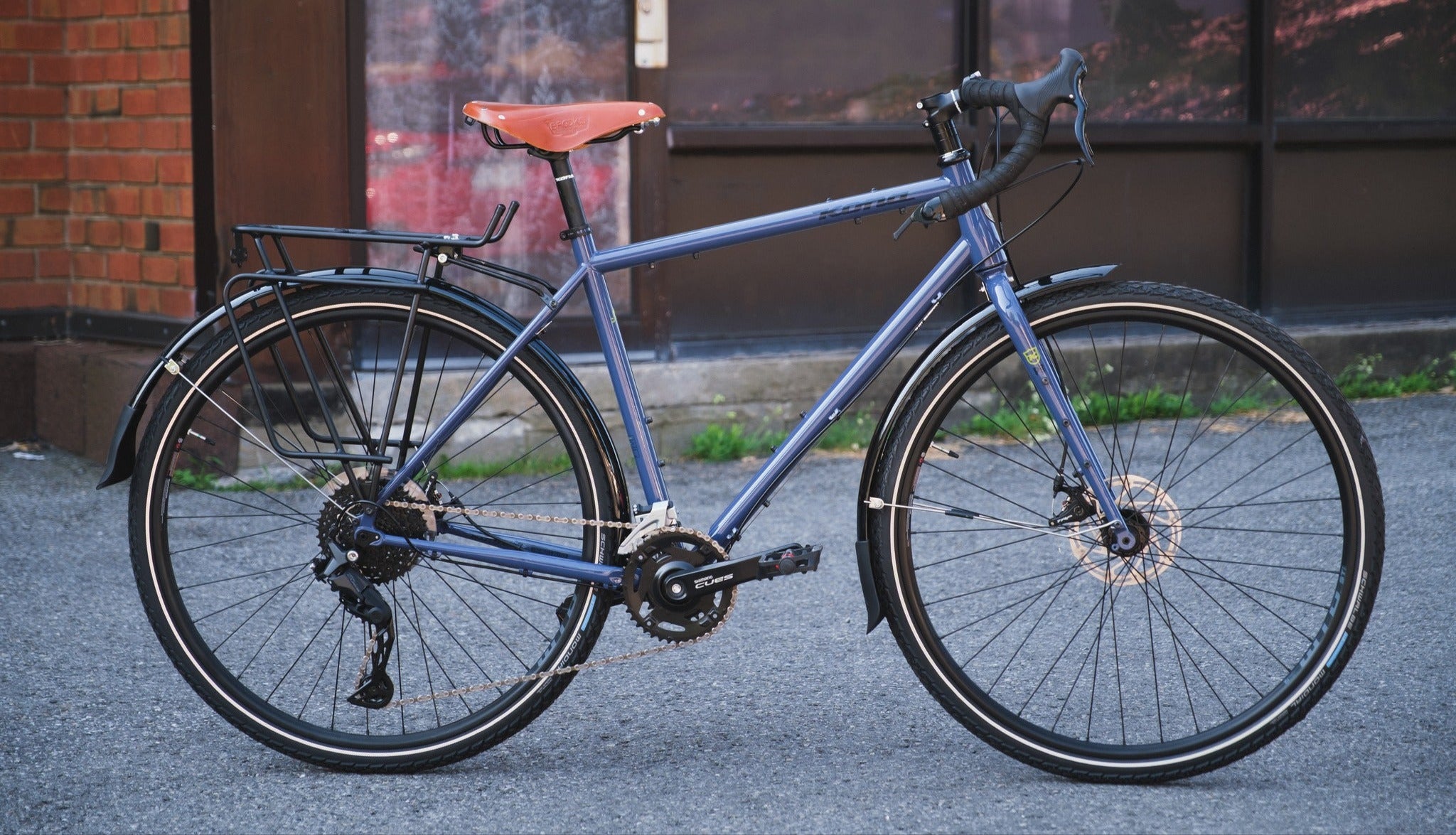 Blue bicycle parked on a street with a building in the background