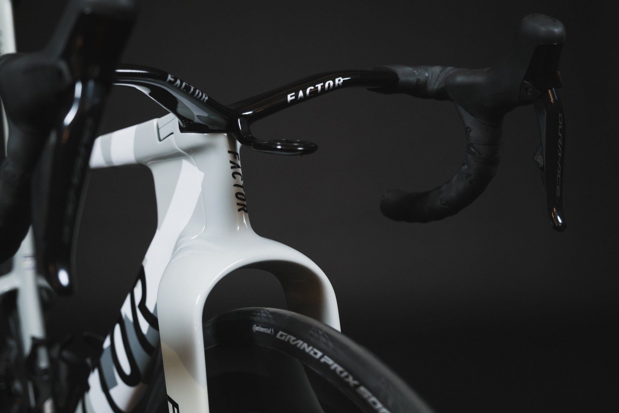 Close-up of a bicycle handlebar with 'Factor' branding on a black background